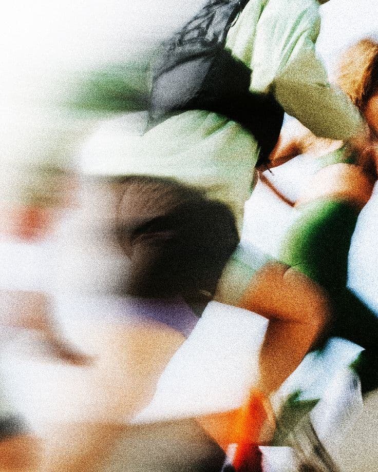 Athletes in motion, photographed at a long exposure so the crowd blurs into colour